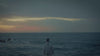 A lone figure looking out at sea. ⁠